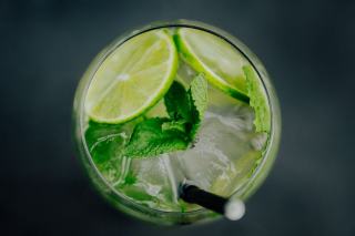 Citron vert coupe et presse-agrumes manuel a cote d un verre de mojito